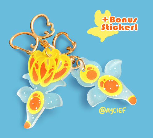 Two sea angel keychains, one with its mouth closed and one with its buccal cones everted. They both have angel wing-shaped clasps.